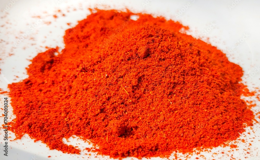 Organic Indian red chilly or chilli pepper spice powder heap or pile scatter and isolated on white background. Closeup macro top side view. Spicy paprika, mirchi and chilli hot food flavouring powder. Organic Indian red chilly or chilli pepper spice powder heap or pile scatter and isolated on white background. Closeup macro top side view. Spicy paprika, mirchi and chilli hot food flavouring powder.