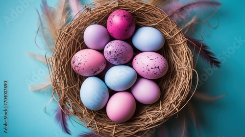  a bird's nest with eggs and feathers on a blue background with a pink and blue speckled egg in the center of the nest, and a purple speckled egg in the middle. photo