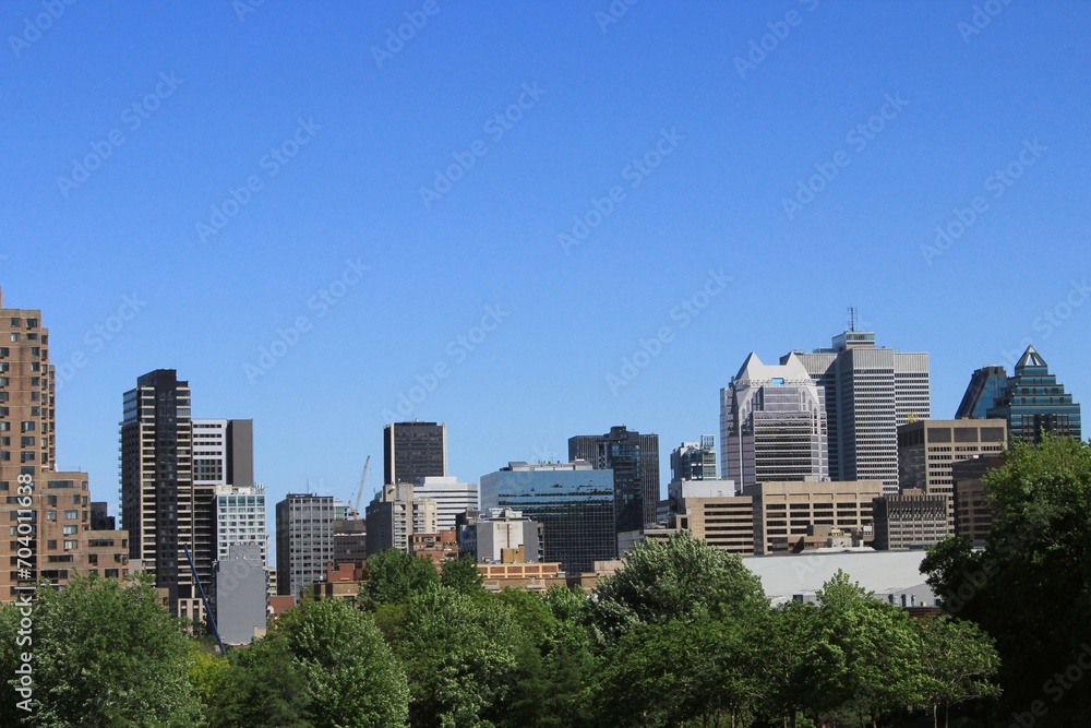 Montreal skyline in Downtown of the city, seen from Griffintown central neighborhood on a summer day. Skyscrapers and high-rise buildings in North America against blue sky.