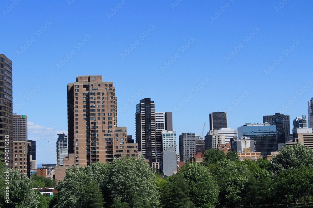 Montreal skyline in Downtown of the city, seen from Griffintown central neighborhood on a summer day. Skyscrapers and high-rise buildings in North America against blue sky.