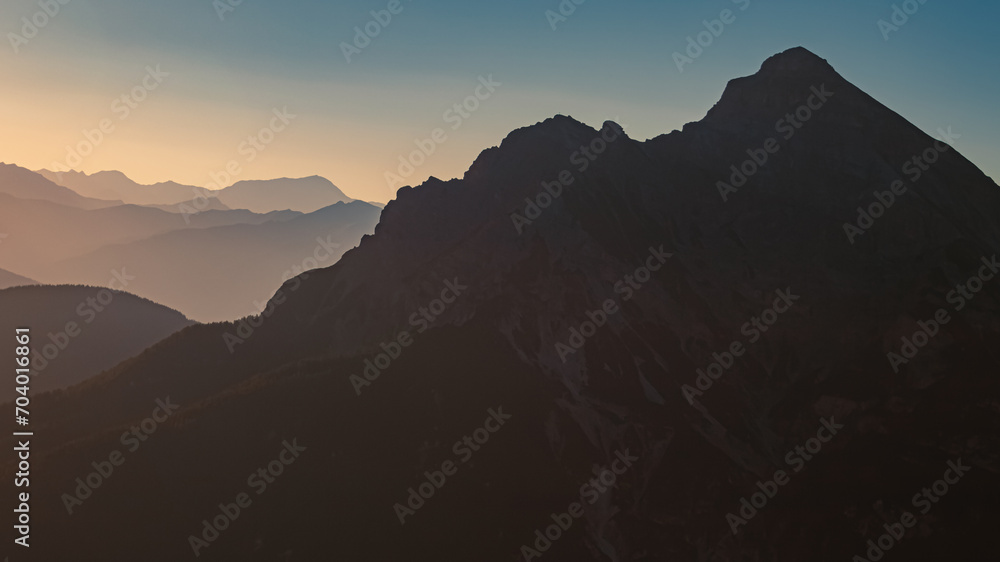 Alpine summer sunrise view with mountain silhouettes at Mount Kreuzjoch, Fulpmes, Stubaital valley, Innsbruck, Tyrol, Austria