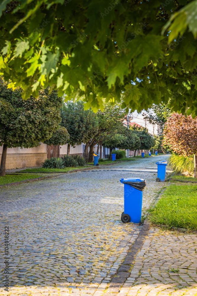Blue garbage cans on the street in a small town near every house Blue garbage cans on the street in a small town near every house
