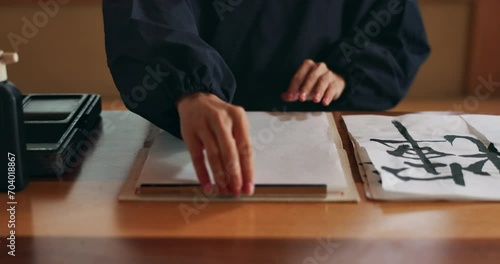 Hands, paper and writing with calligraphy or Asian script for art with inkstone, ink and prepare. Japanese creativity, black paint and vintage tools, paintbrush and person with traditional stationery photo