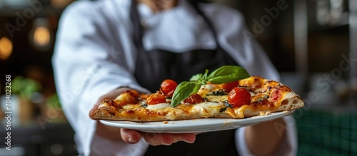 Woman chef holds a piece of delicious homemade pizza.