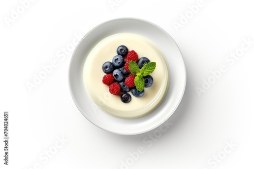  a bowl of yogurt with blueberries and raspberries on top of it with a mint leaf on top of the yogurt in a white bowl.