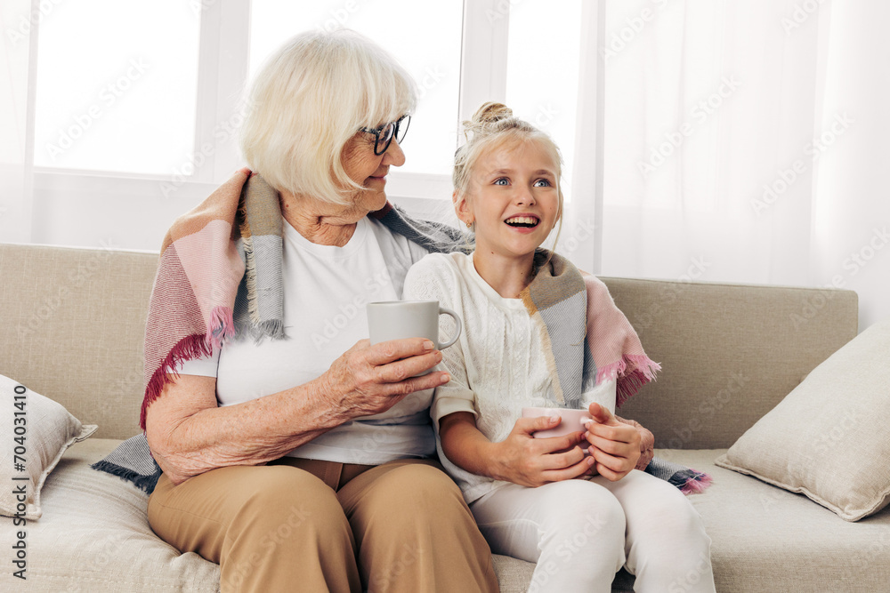 Girl plaid couch winter granddaughter mugs grandmother child hugging sofa Girl plaid couch winter granddaughter mugs grandmother child hugging sofa