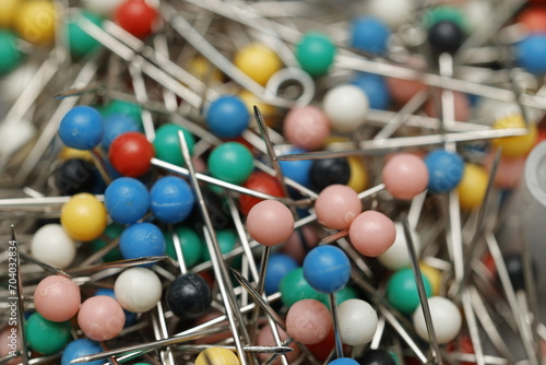 A close-up view of colorful push pins and needles