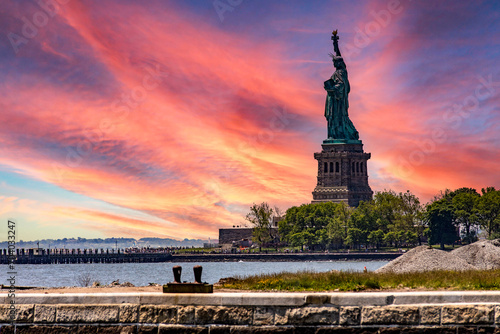 Wonderful sunrise view of the Statue of Liberty in New York (USA), from Ellis Island where the immigration museum of the Big Apple is located.