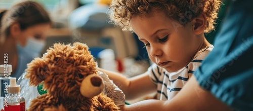 Child receiving flu shot at clinic or hospital with comforting toy photo