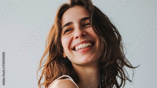 Radiant Woman Laughing Freely with Sunlight Enhancing Her Wavy Brunette Hair