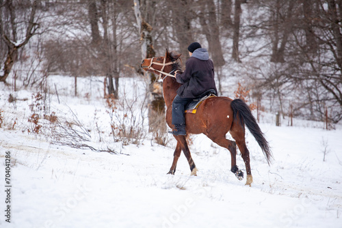 Horse rider gallops on a snowy mountain in Bakuriani © k_samurkas