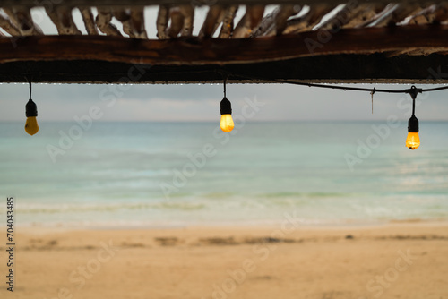 Vintage light bulb on the beach against the background of the sea and sky.