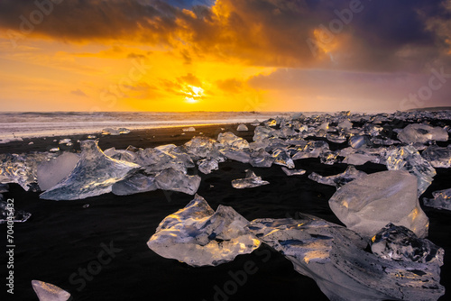 Amazing sunset over the Diamond Beach, volcanic black beach with icebergs from the Jokulsarlon glacier lagoon, Iceland