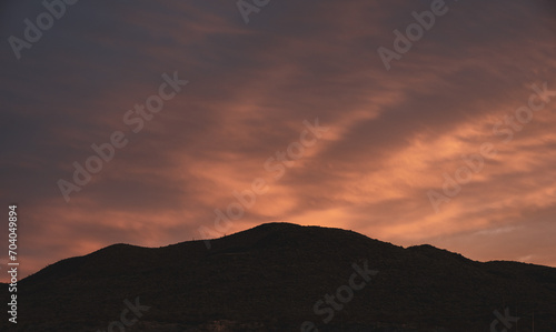 Rows Of Clouds With Pink Tint In The Sky And Silhouetted Hill Side In Big Bend