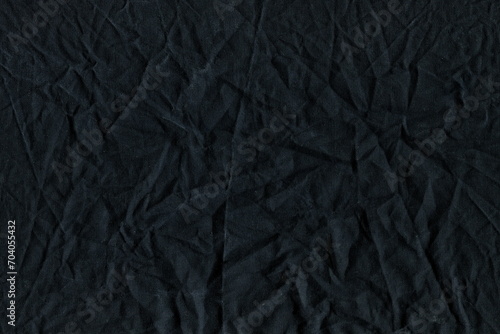 The texture of the wrinkled natural fabric is black and gray. Working fabric. Cotton crumpled rag, burlap. Abstract monochrome background.