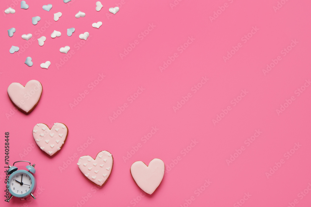 Heart shaped sweet cookies with confetti and alarm clock on pink background. Valentine's day celebration