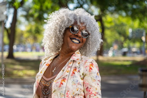 Stylish, smiling afro lady with grey afro hairstyle in sunny city photo