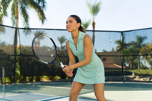 Active latin woman exercising playing a tennis game photo