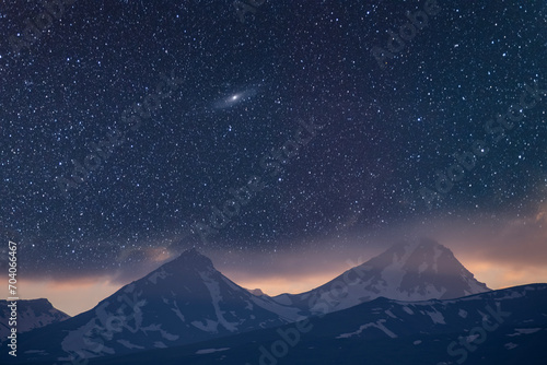 Beautiful night landscape. Snow covered mountains under beautiful bright Milky Way Galaxy. © Inga Av