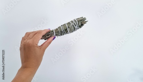 Bundle of dry white sage, Salvia officinalis, isolated on a grey background.