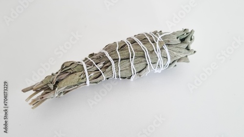 Bundle of dry white sage, Salvia officinalis, isolated on a grey background.