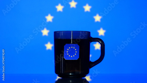 Close-up of a cup of tea with a EU flag tag hanging from it
