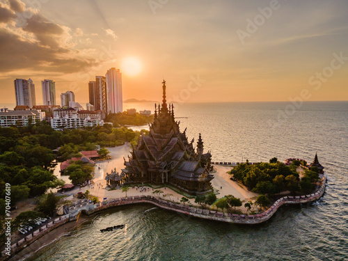 Skyline of Pattaya city at sunset with The Sanctuary of Truth wooden temple in Pattaya Thailand, gigantic wooden construction located at the cape of Naklua Pattaya City Chonburi Thailand photo