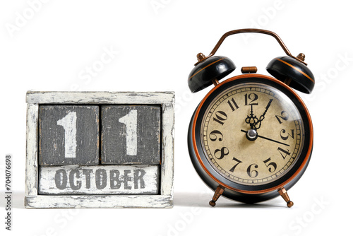 October 11 on wooden calendar with alarm clock white background. photo