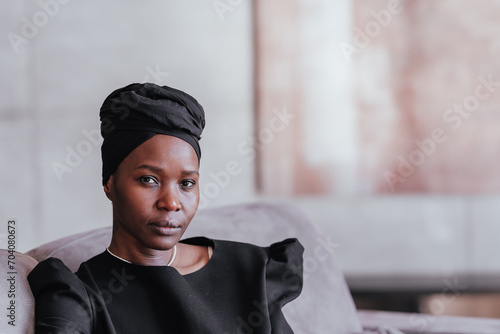 Obraz na plátně African woman in black dress and headscarf with a contemplative look