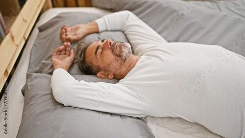 Young hispanic grey-haired man lying on bed sleeping at bedroom photo