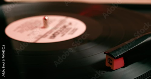 Vinyl record close-up. Vintage old vinil black phonograph spinning. Retro music player on living room home background in evening. photo