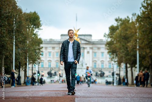 casual young man enjoying a serene moment at the majestic buckingham palace, a fusion of modern casual fashion and historical elegance in london's heart photo