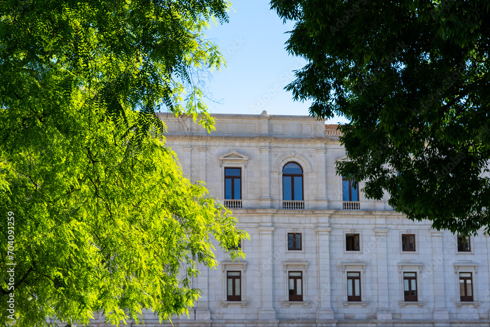 view through trees of the facade of the assembly of the Portuguese republic.