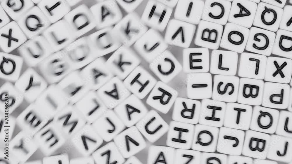 Close-up lot of white plastic decorative cubes with alphabet letters moving randomly Close-up lot of white plastic decorative cubes with alphabet letters moving randomly