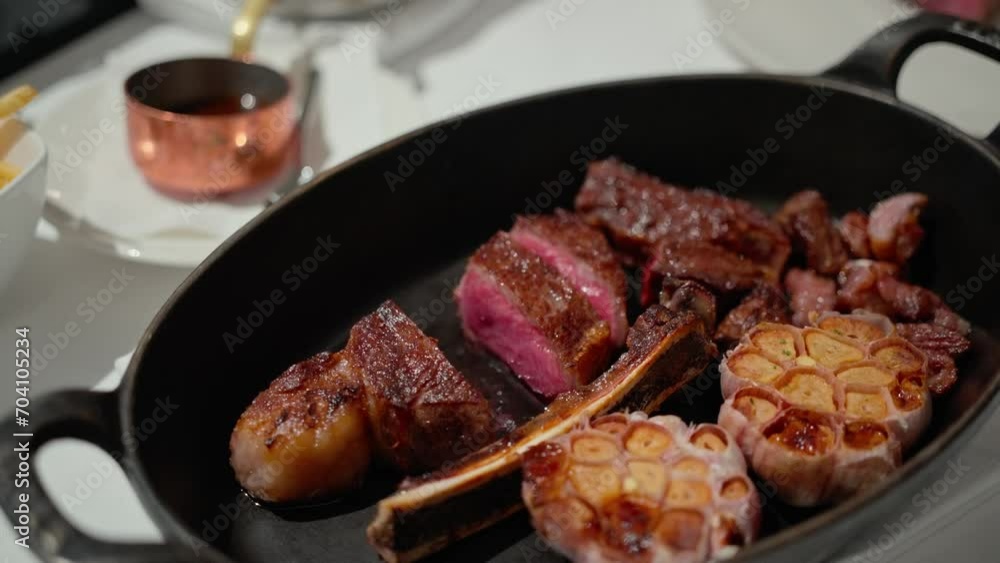 Juicy beef steak with garlic sliced on the plate in restaurant Juicy beef steak with garlic sliced on the plate in restaurant