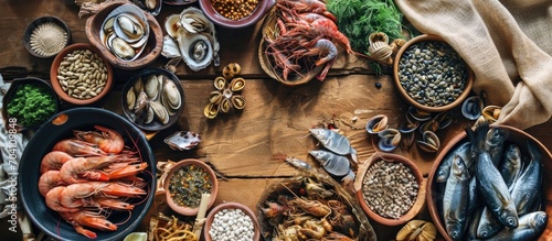 Assorted seafood, seeds, and snacks on a wooden table with a traditional cloth.