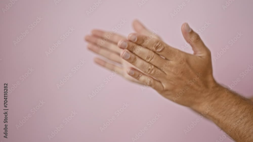 A blurred image of a man's hands clapping against a pink background, conveying movement and emotion.