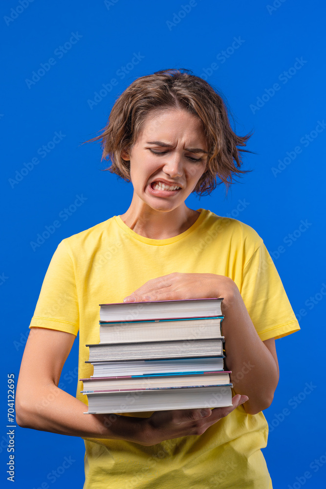 Lazy woman student is dissatisfied with amount of books homework on blue Lazy woman student is dissatisfied with amount of books homework on blue