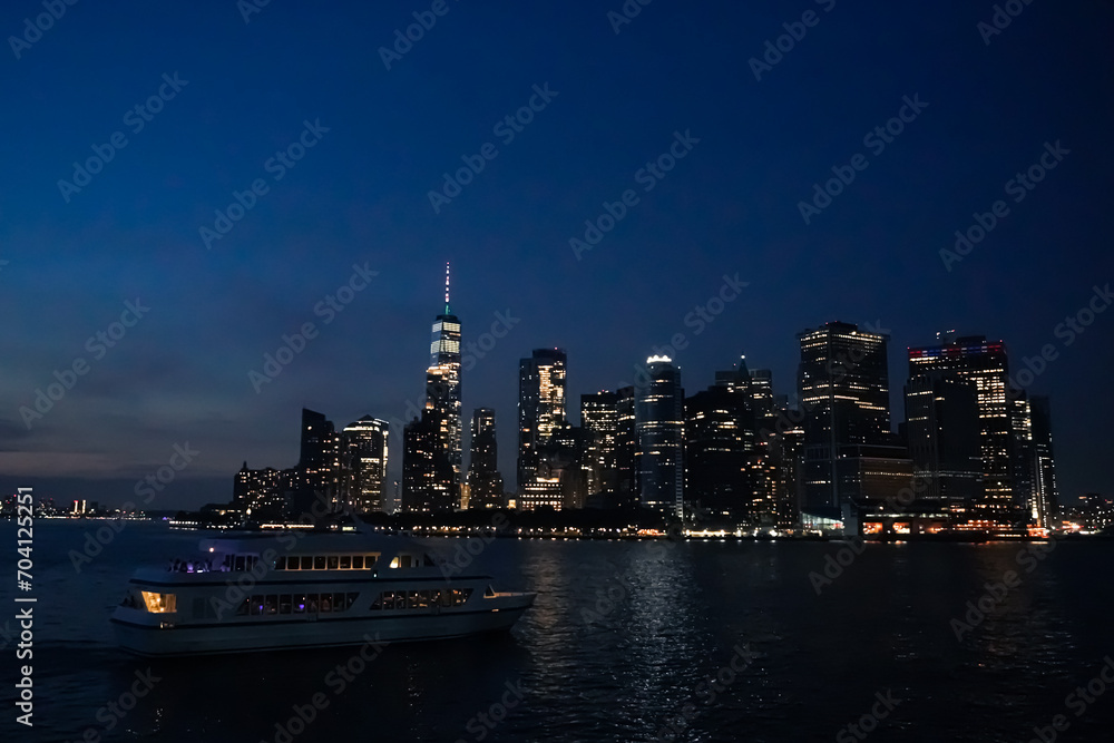 Boat parties in the Hudson River next to the New York skyline at night