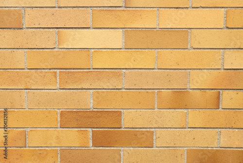 A yellow brick pattern wall texture. This close up of rustic brick colors is intended for a background use of the stone working idea. Old, worn bricks.