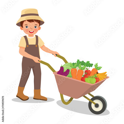 Cute little boy gardener pushing wheelbarrow full of fruits and vegetables