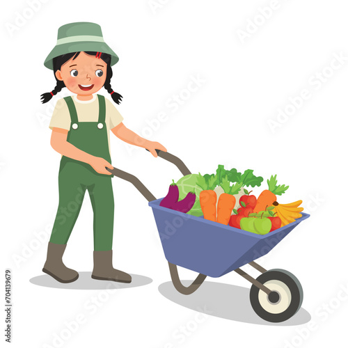 Cute little girl gardener pushing wheelbarrow full of fruits and vegetables