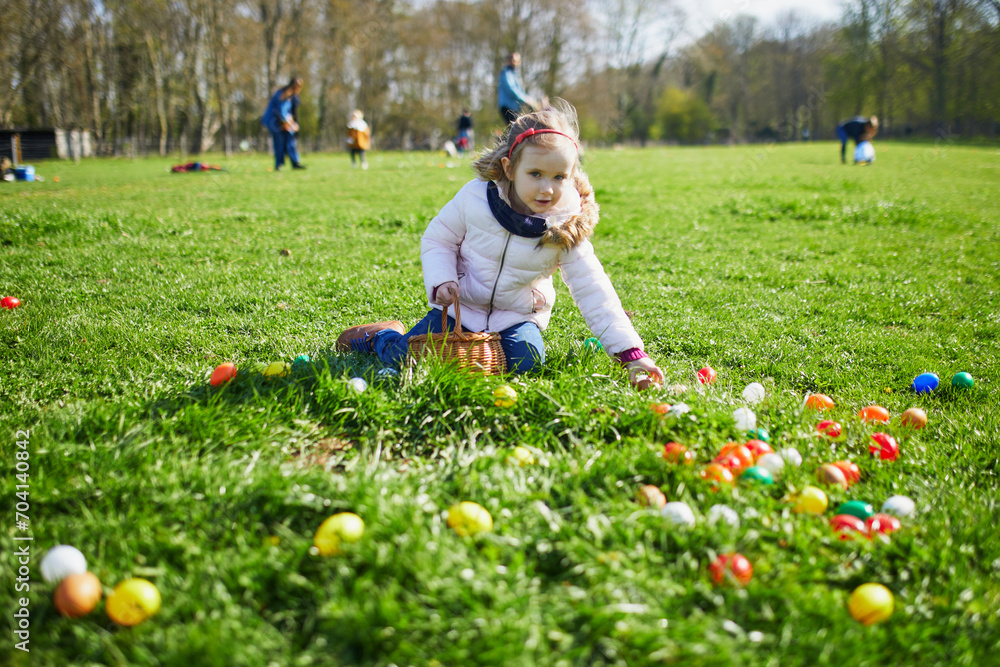 Adorable preschooler girl playing egg hunt on Easter Adorable preschooler girl playing egg hunt on Easter