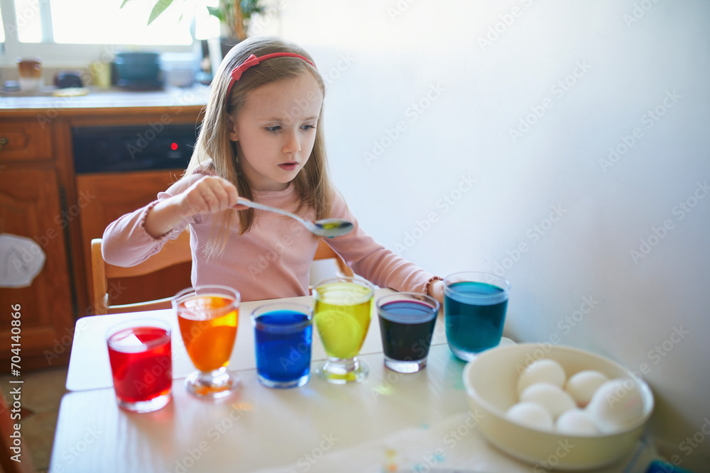 Adorable preschooler girl dyeing Easter eggs at home Adorable preschooler girl dyeing Easter eggs at home