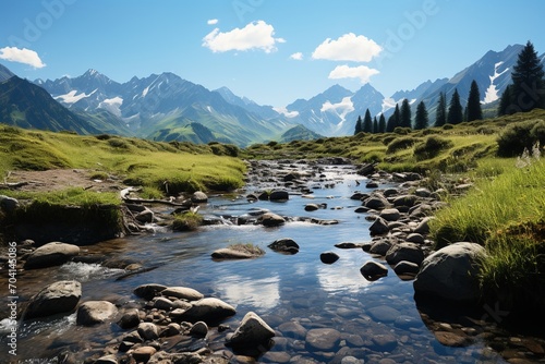 Mountain stream in a valley with snow capped mountains in the distance