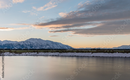 Mount Hutt and Canterbury Plains at sunset with frozen dam in foreground