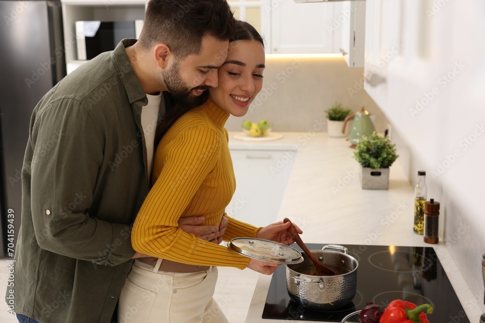 Lovely couple enjoying time together while cooking in kitchen Lovely couple enjoying time together while cooking in kitchen