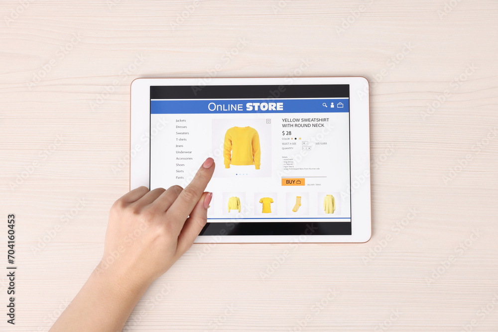 Woman with tablet shopping online at white wooden table, top view Woman with tablet shopping online at white wooden table, top view