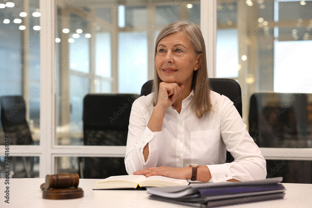 Portrait of confident lawyer working at table in office Portrait of confident lawyer working at table in office