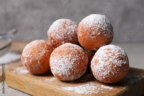 Delicious sweet buns with powdered sugar on table, closeup photo